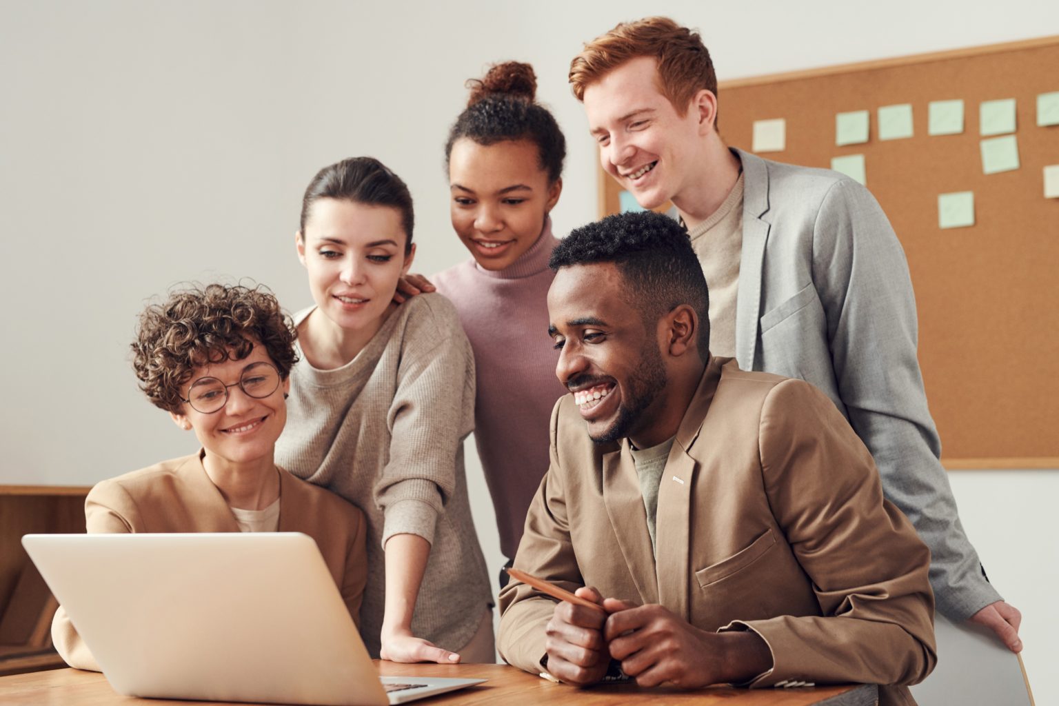 a group of people looking at a laptop