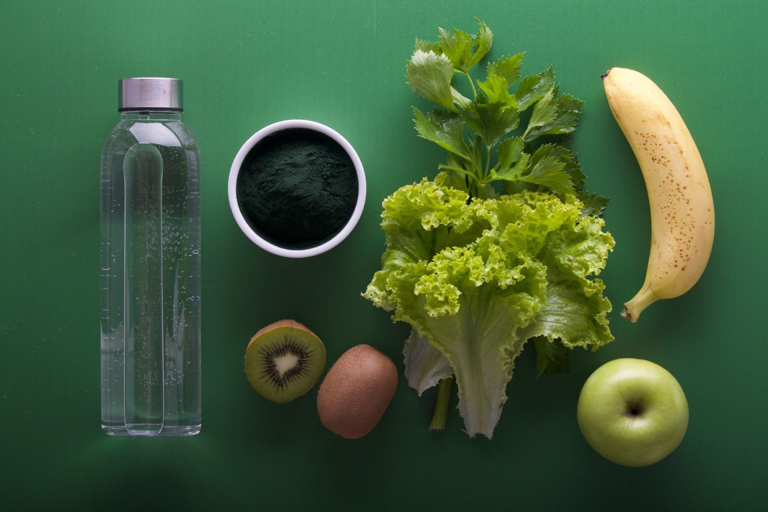 a bottle of liquid next to a couple of fruits and a glass of milk