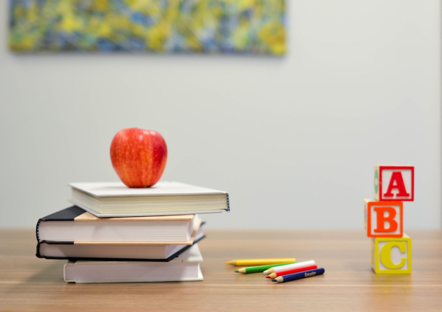 a red apple on a stack of books