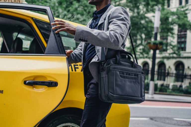 a man and woman walking down the street with a yellow car