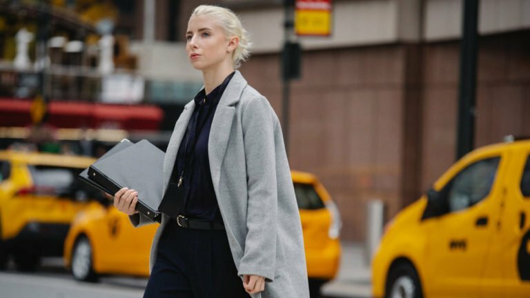 a person in a white suit walking on a street