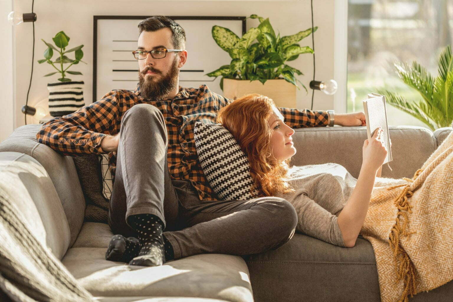 a man and a woman playing video games on a couch