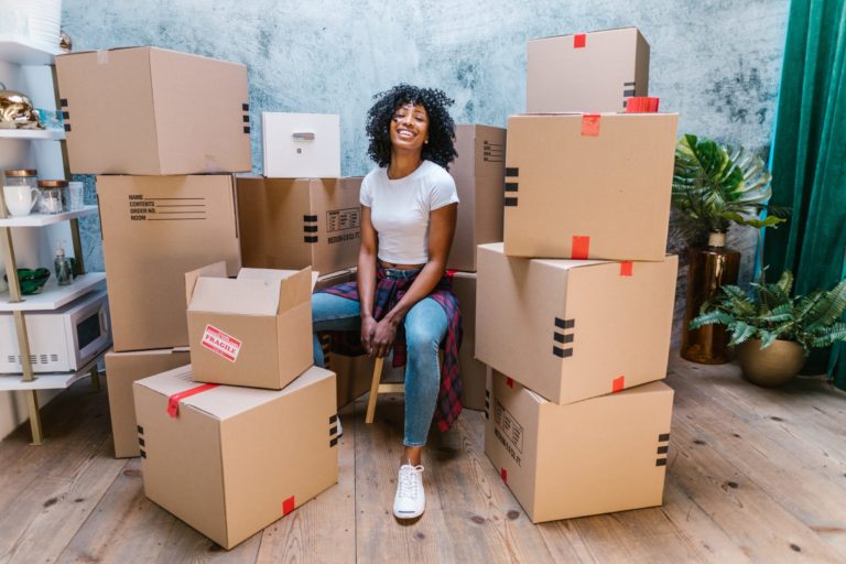 a person sitting on a chair surrounded by boxes