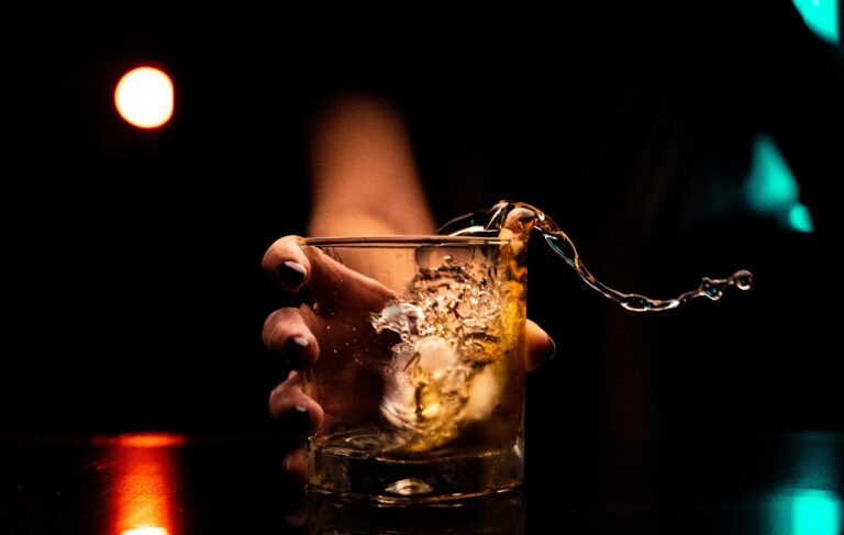 a hand pouring a drink into a glass