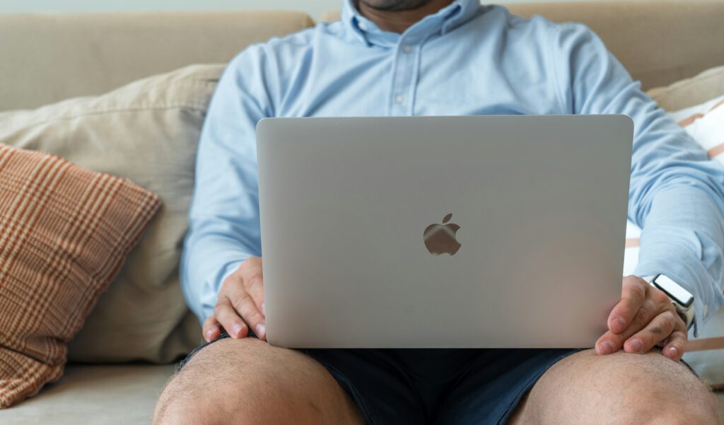 a man sitting on a couch with a laptop